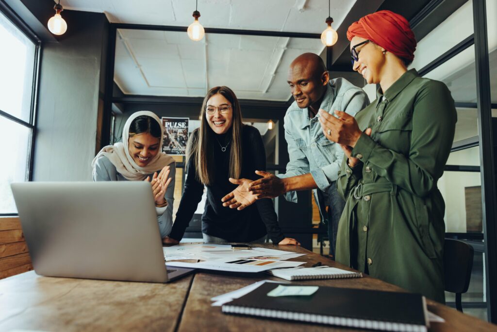 Successful interior designers applauding cheerfully during an online meeting. Group of multicultural businesspeople celebrating their achievement during a video conference.